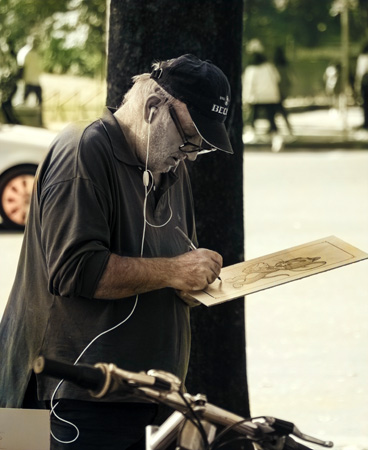 A man sketching, on site, as in a sketchcrawl.